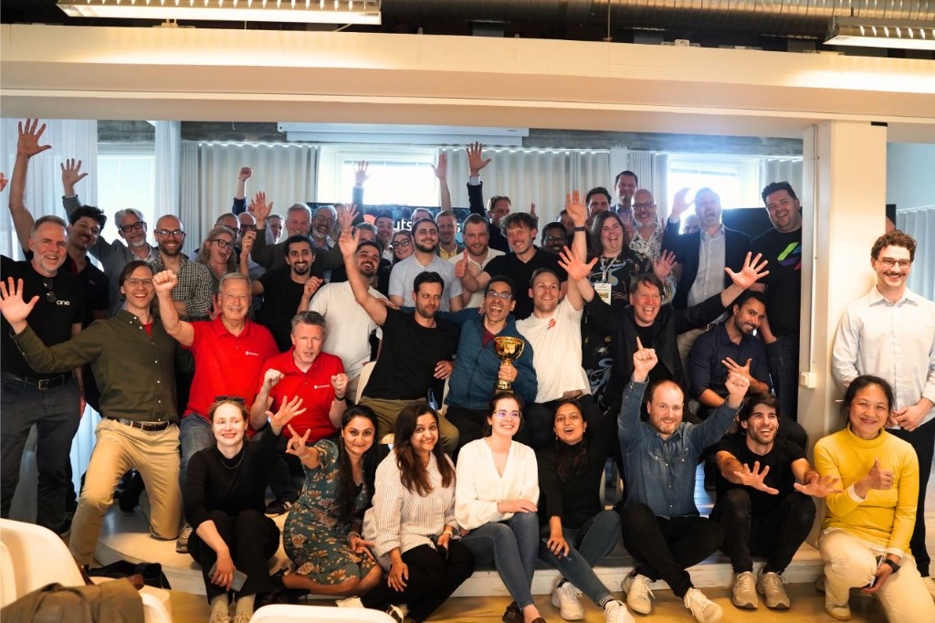 Brainiacs and participants at the OutSystems AI + Low-Code Hackathon in Malmö, with 1st place trophy